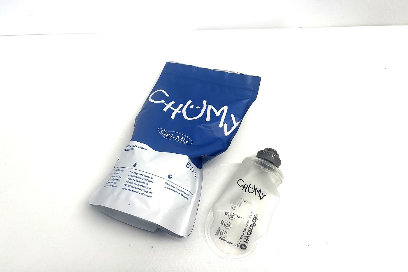 Chumy Packung Ein Beutel Energie-Gel-Pulver und eine Soft Flask auf einem Tisch.